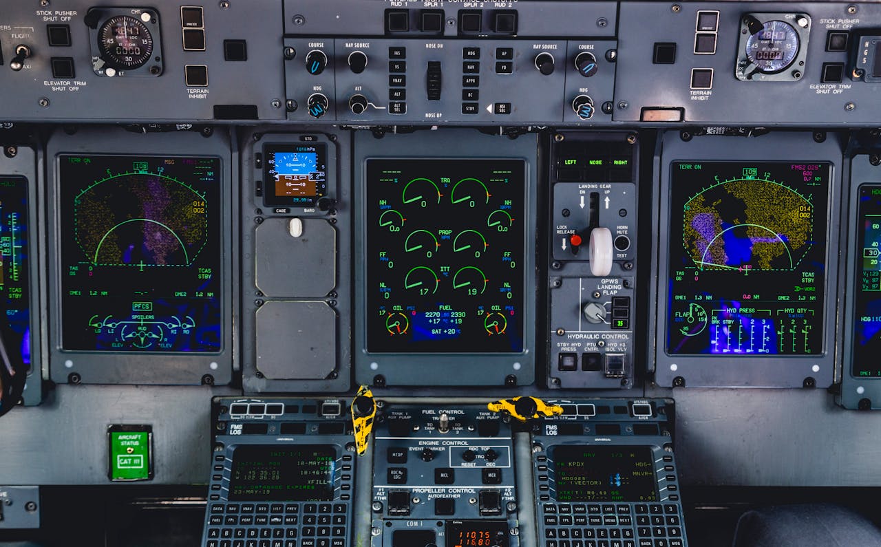 about-06 Detailed view of an aircraft cockpit control panel with various screens and controls.