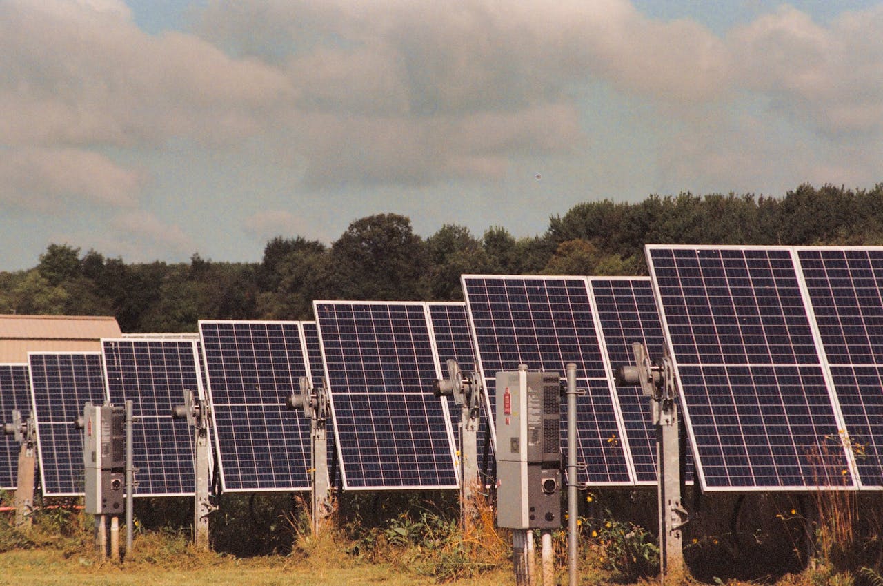 services-09 Solar panels in a field generating clean, renewable energy on a sunny day.